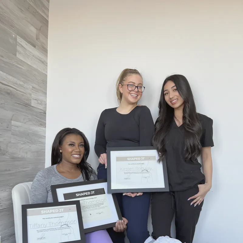 Three women holding their certificates on training day