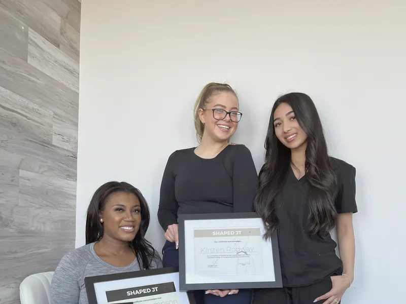 Three women holding their certificates on training day