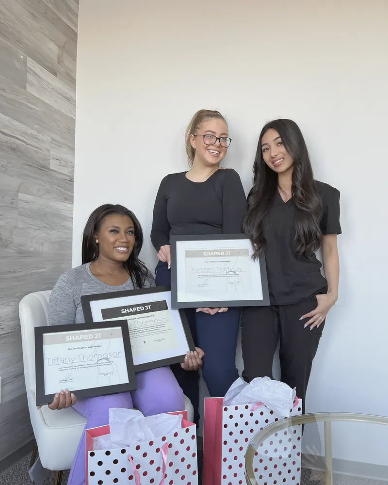 Three women holding their certificates on training day