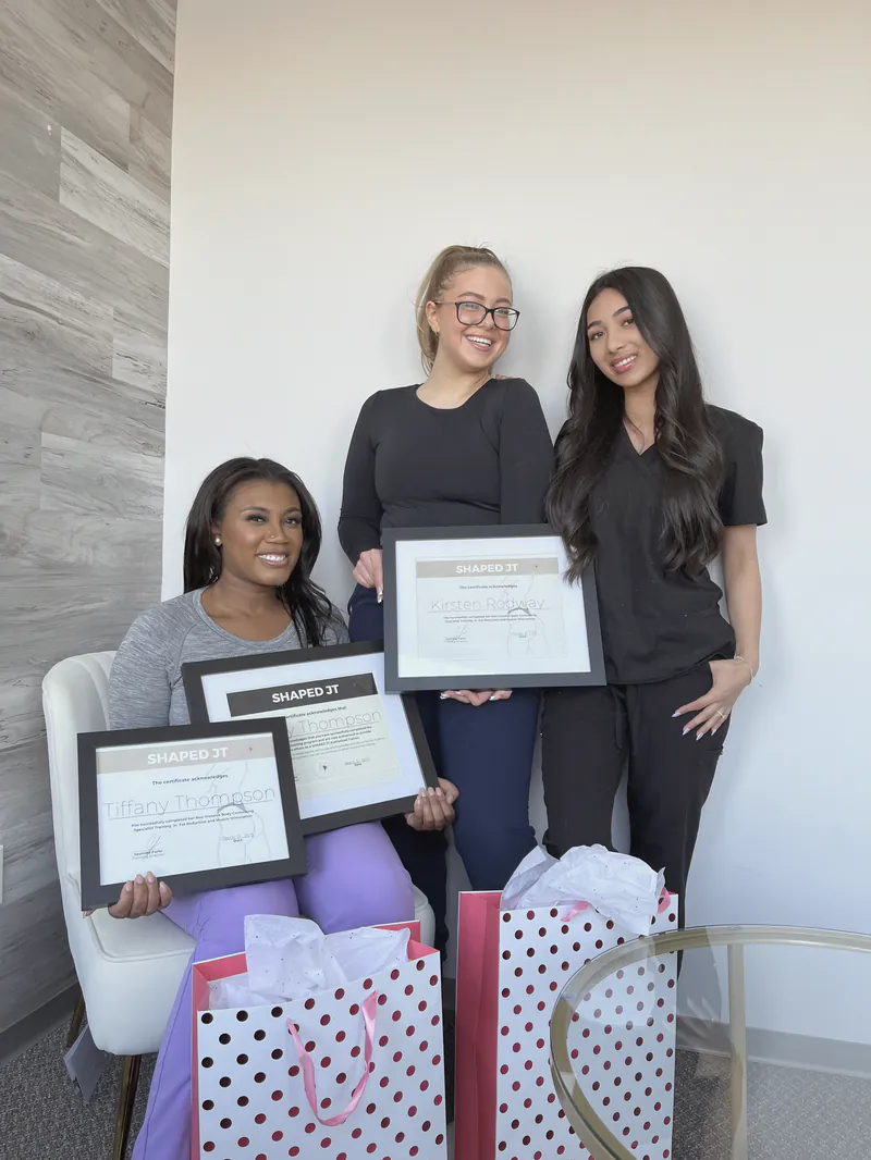 Three women holding their certificates on training day
