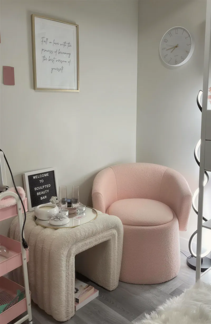A pink chair and side table in a calm studio corner