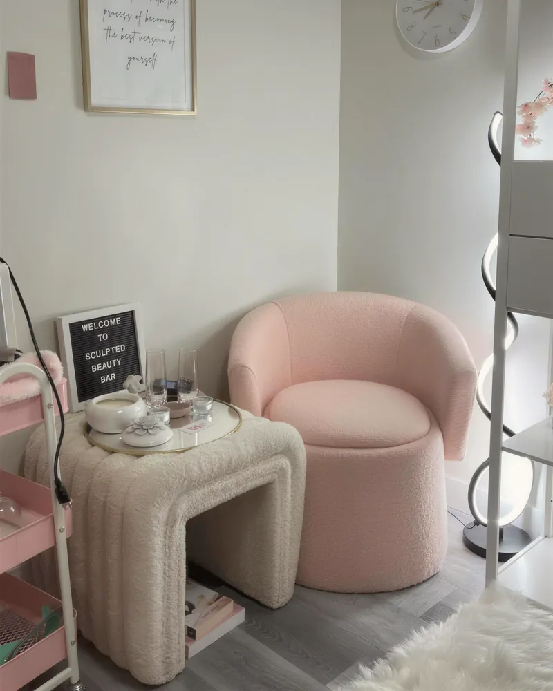 A pink chair and side table in a calm studio corner