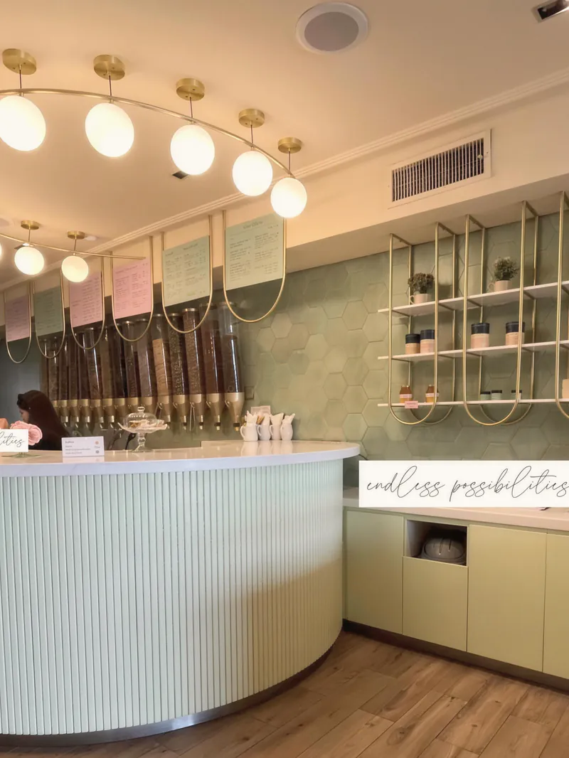 A café counter with globe lights and a curved white bar