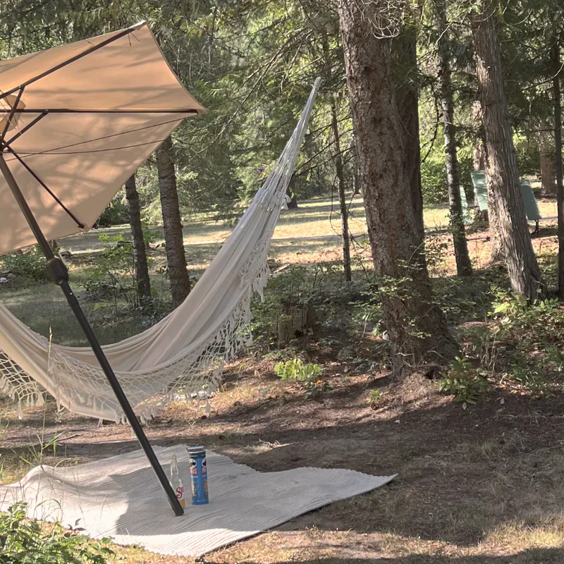 A garden terrace with a shade umbrella among the trees