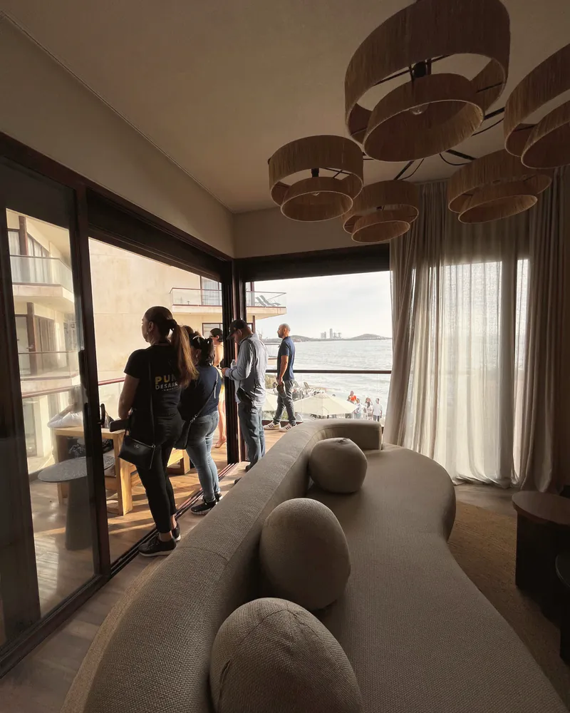 A moody lounge with long tables looking out to the water