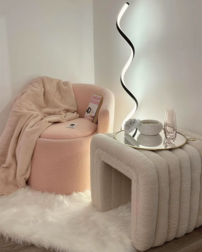 A cozy pink velvet chair, sculptural lamp and faux-fur rug