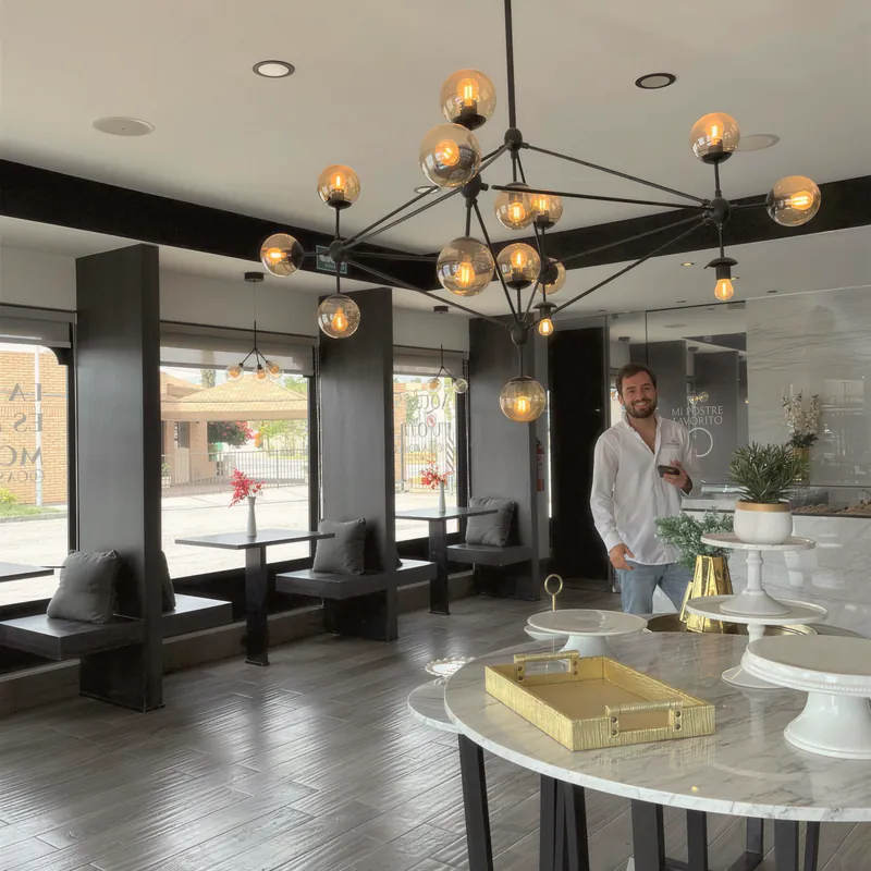 A bright commercial studio with a statement chandelier and marble table
