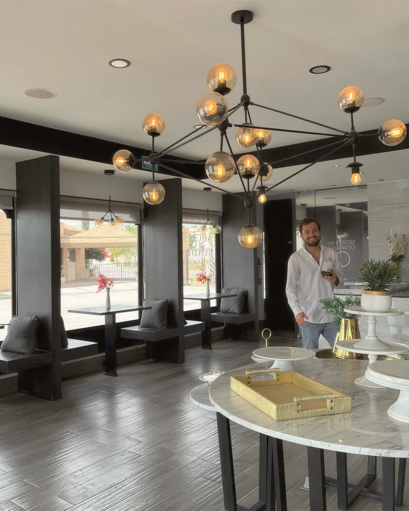 A bright commercial studio with a statement chandelier and a marble table